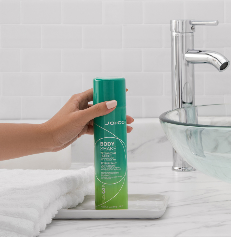 body shake finisher product in hand near sink