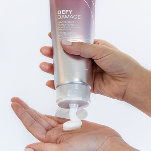 Defy damage conditioner showing product in hand